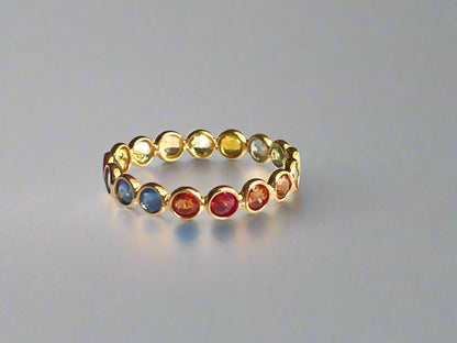 Multicolored gemstone ring on a reflective surface