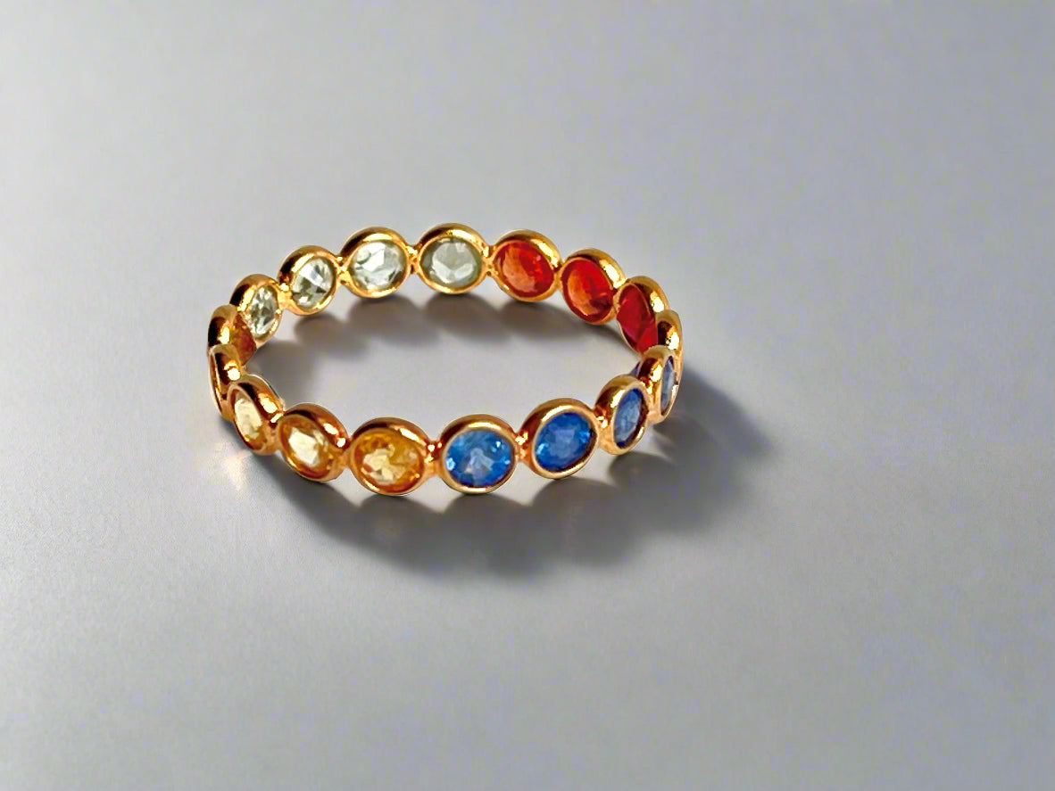 Gold ring with multicolored gemstones on a white background