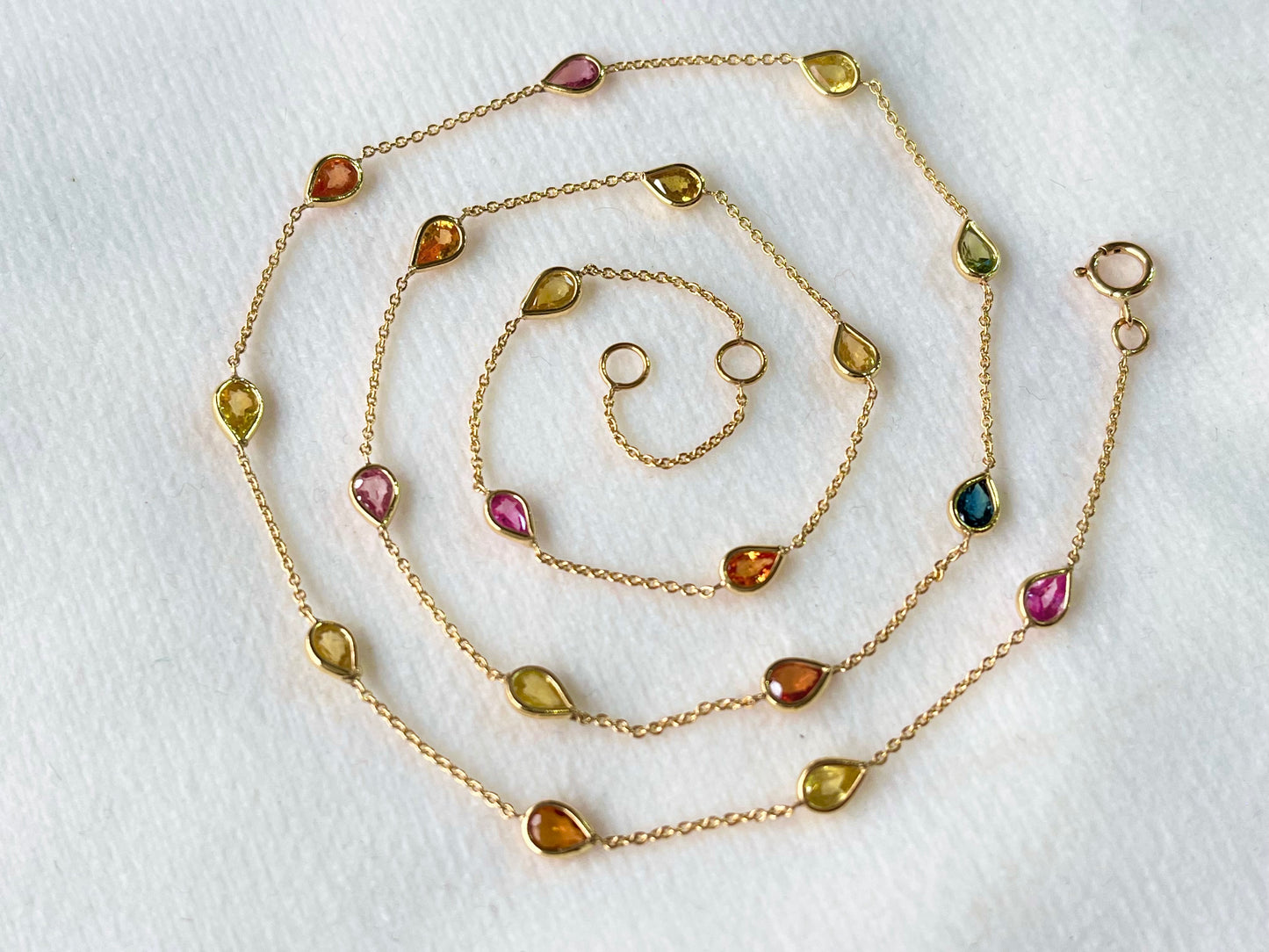 Gold necklace with gemstones on a white background