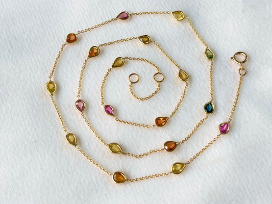 Gold necklace with gemstones on a white background
